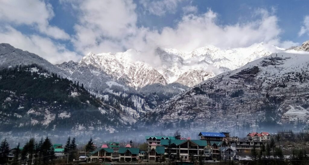 Snow-covered mountains and pine trees in Manali, Himachal Pradesh, India during winter.