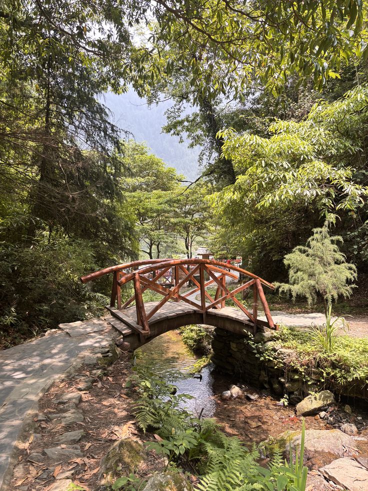 Jibhi Waterfall cascading through green forests in Himachal Pradesh, surrounded by scenic mountains.