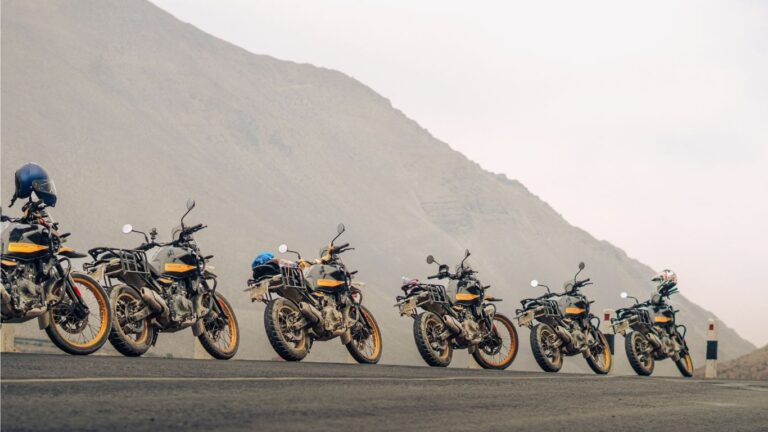 Lineup of adventure motorcycles parked on a scenic mountain road for tourist bike rental travel.