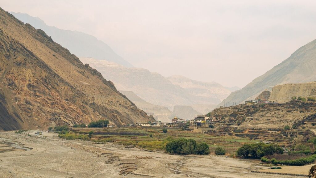 Scenic mountain valley near Manali with village landscape, ideal destination for bike trip in Manali.